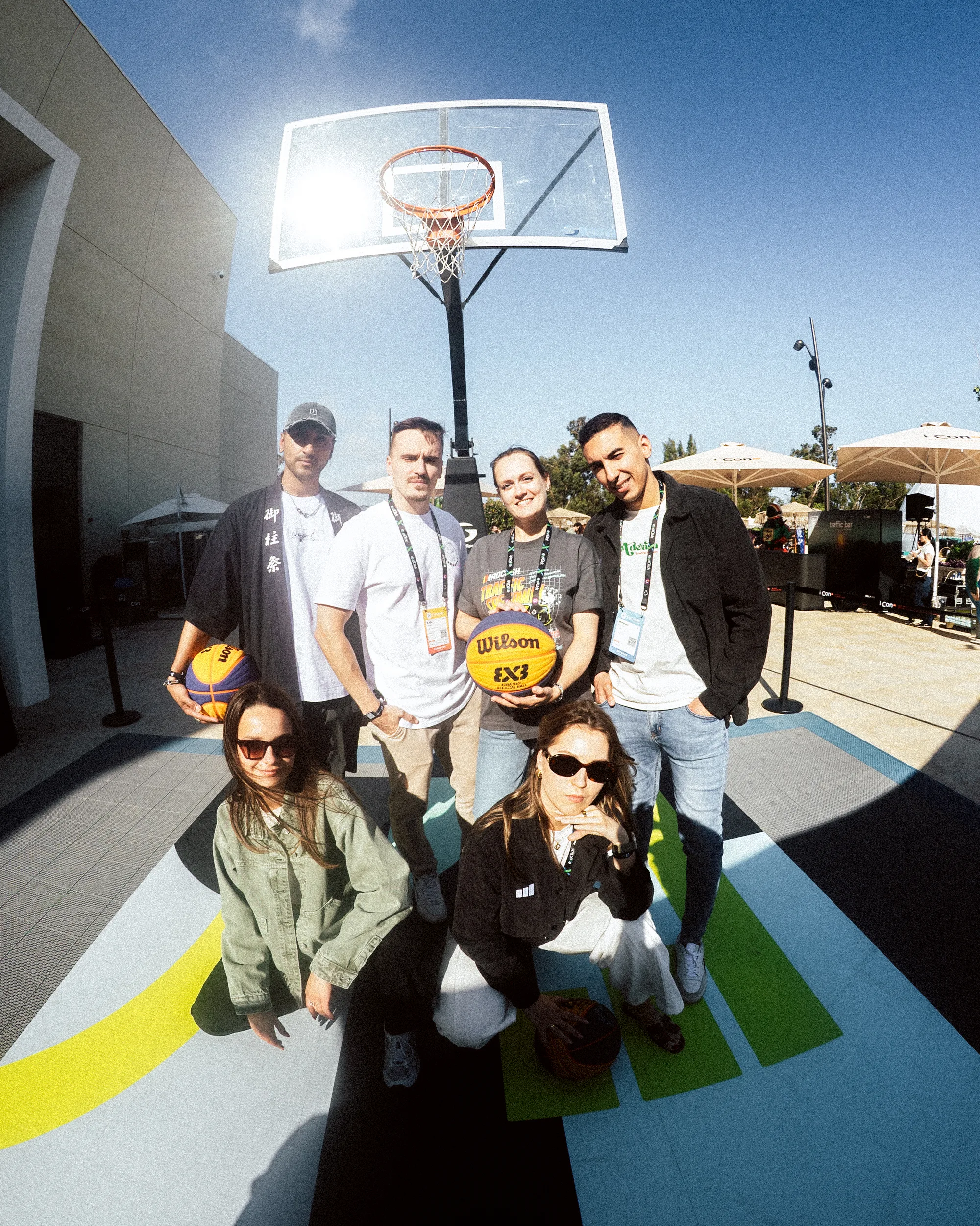 Adcash employees standing in front of their branded basketball court at iCon 2026
